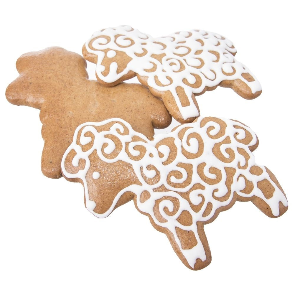 Dos galletas de jengibre con forma de oveja, decoradas con glaseado blanco.