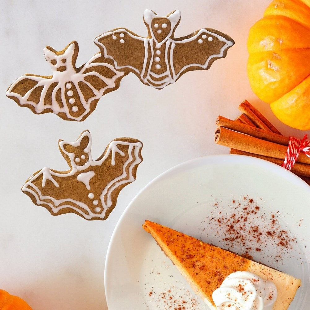 Murciélagos de pan de jengibre sobre pastel de calabaza, canela y una calabaza.