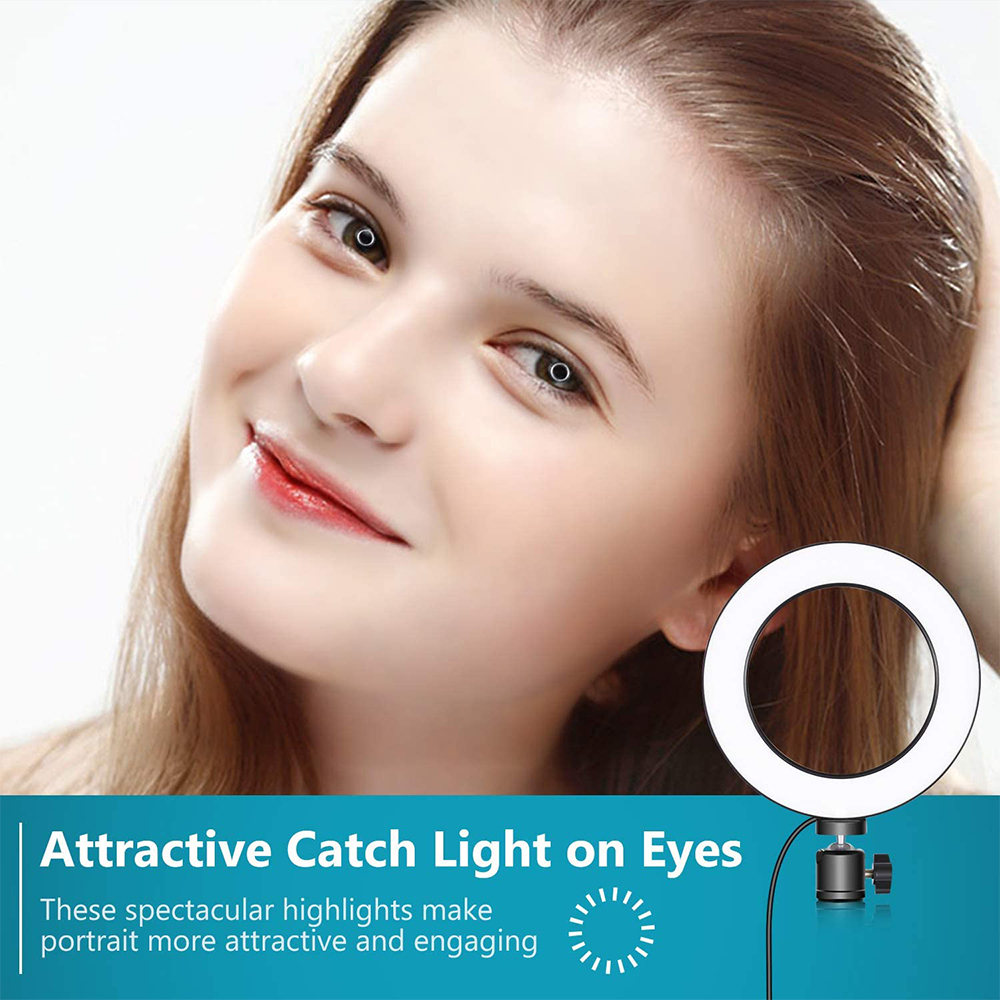 Frau mit Ringlicht, das sich in ihren Augen spiegelt. Heller Hintergrund.