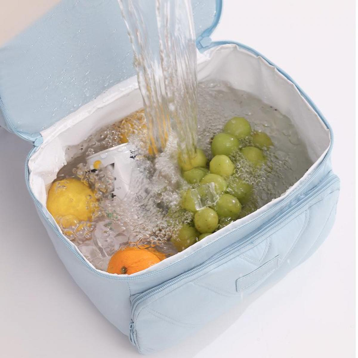 Früchte werden in einer blauen Tasche mit Wasser gespült.