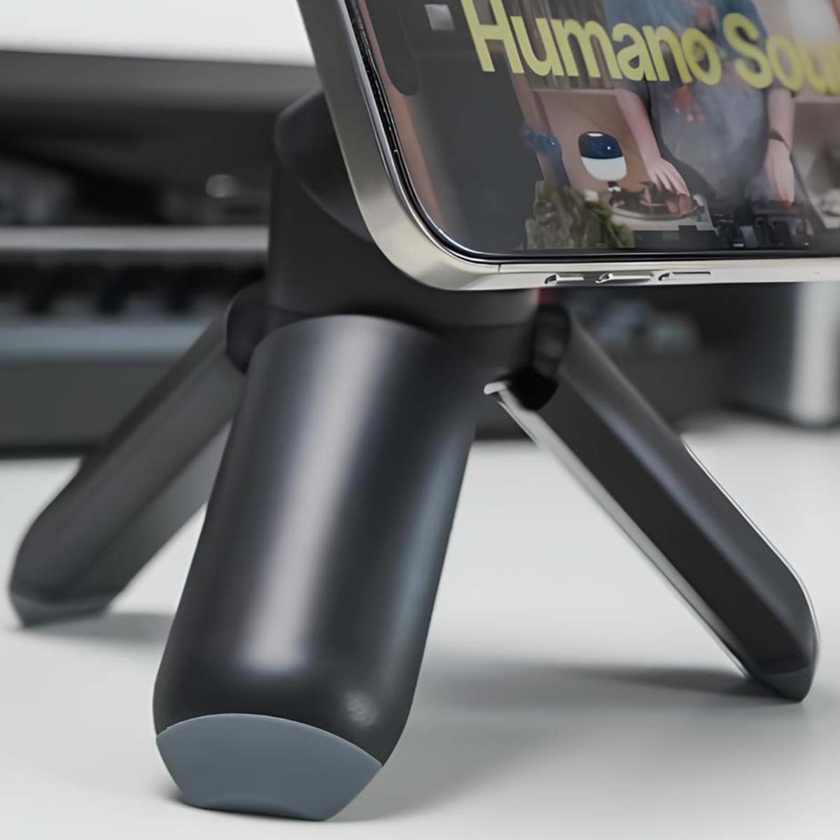 Nahaufnahme eines schwarzen Mini-Stativs mit einem Handy, das darauf montiert ist.