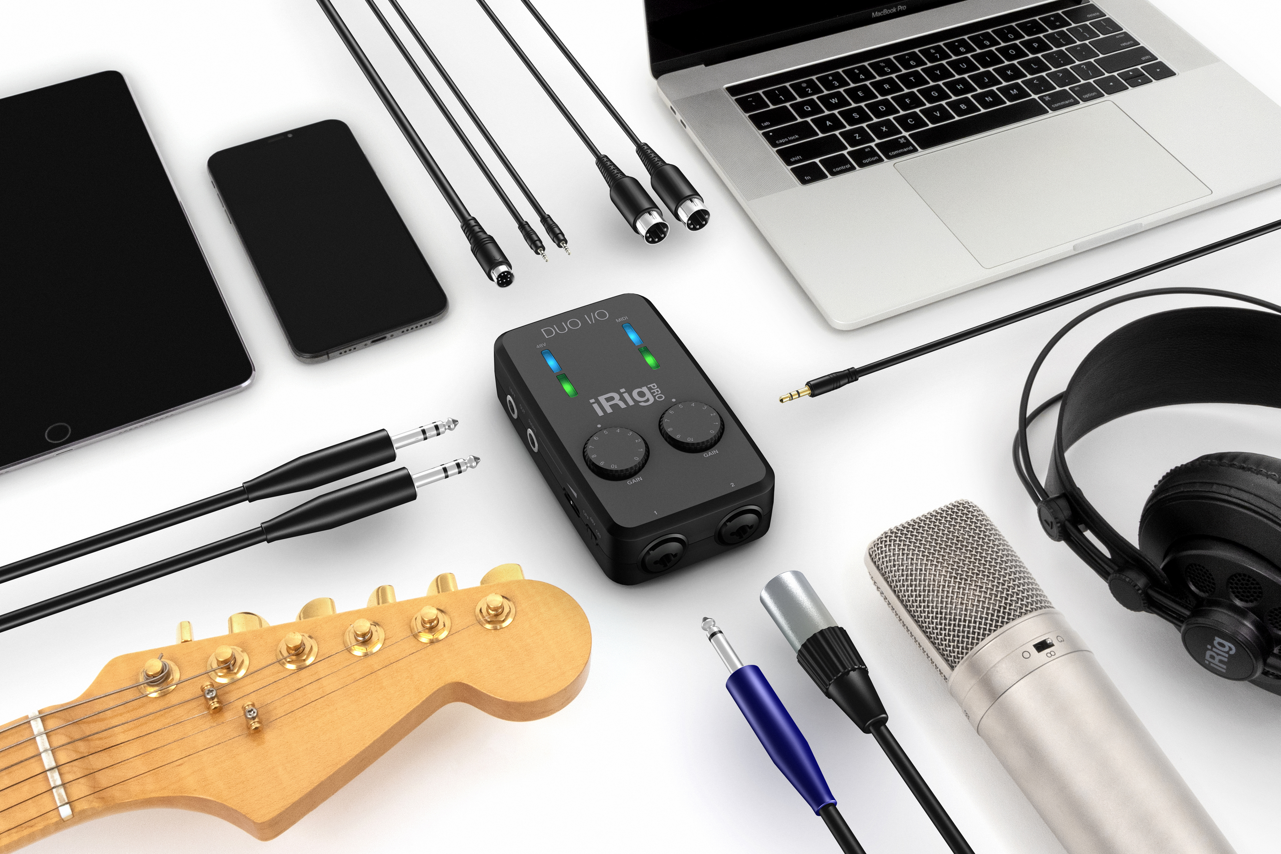 Ein MacBook Pro, Tablet, Smartphone, Gitarrenkopf, Mikrofon, Kopfhörer und Audio-Interface.
