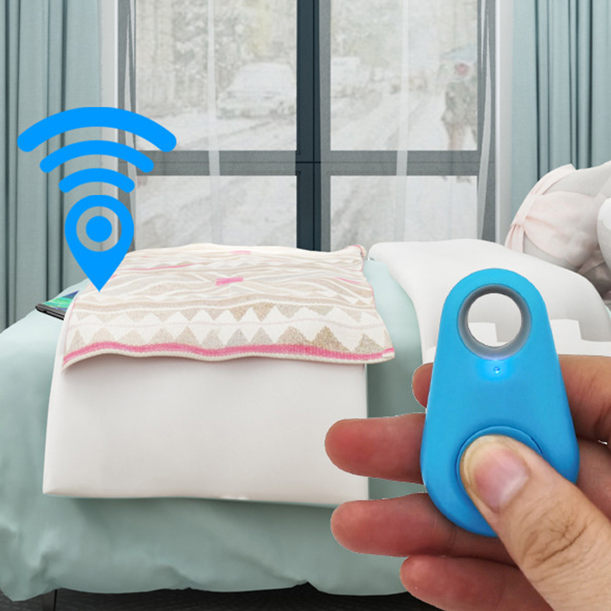 Ein blauer Tracker-Tag wird in einer Hand in der Nähe eines Bettes mit gemusterter Decke gehalten.