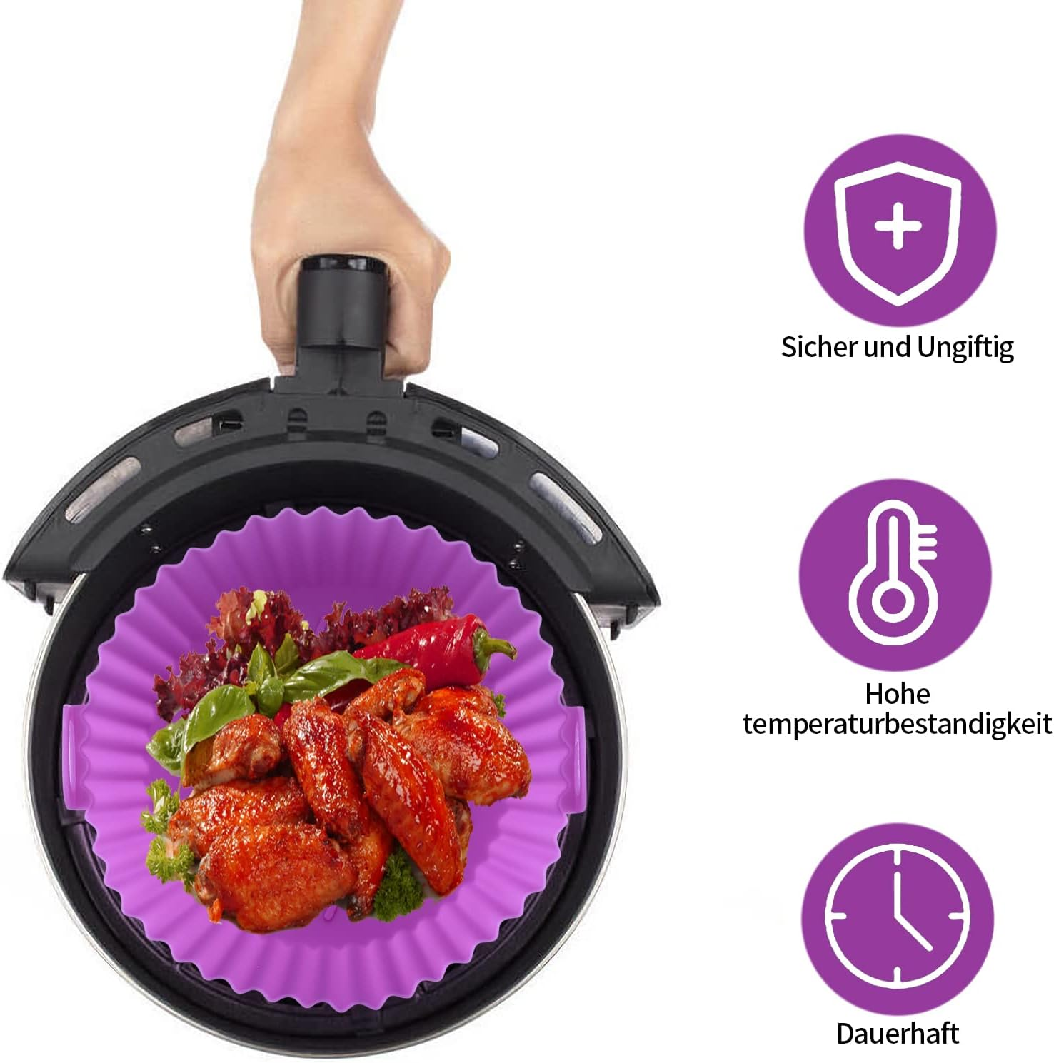 Ein lila Airfryer-Einsatz mit Hähnchenflügeln und Gemüse wird aus einem Airfryer genommen.