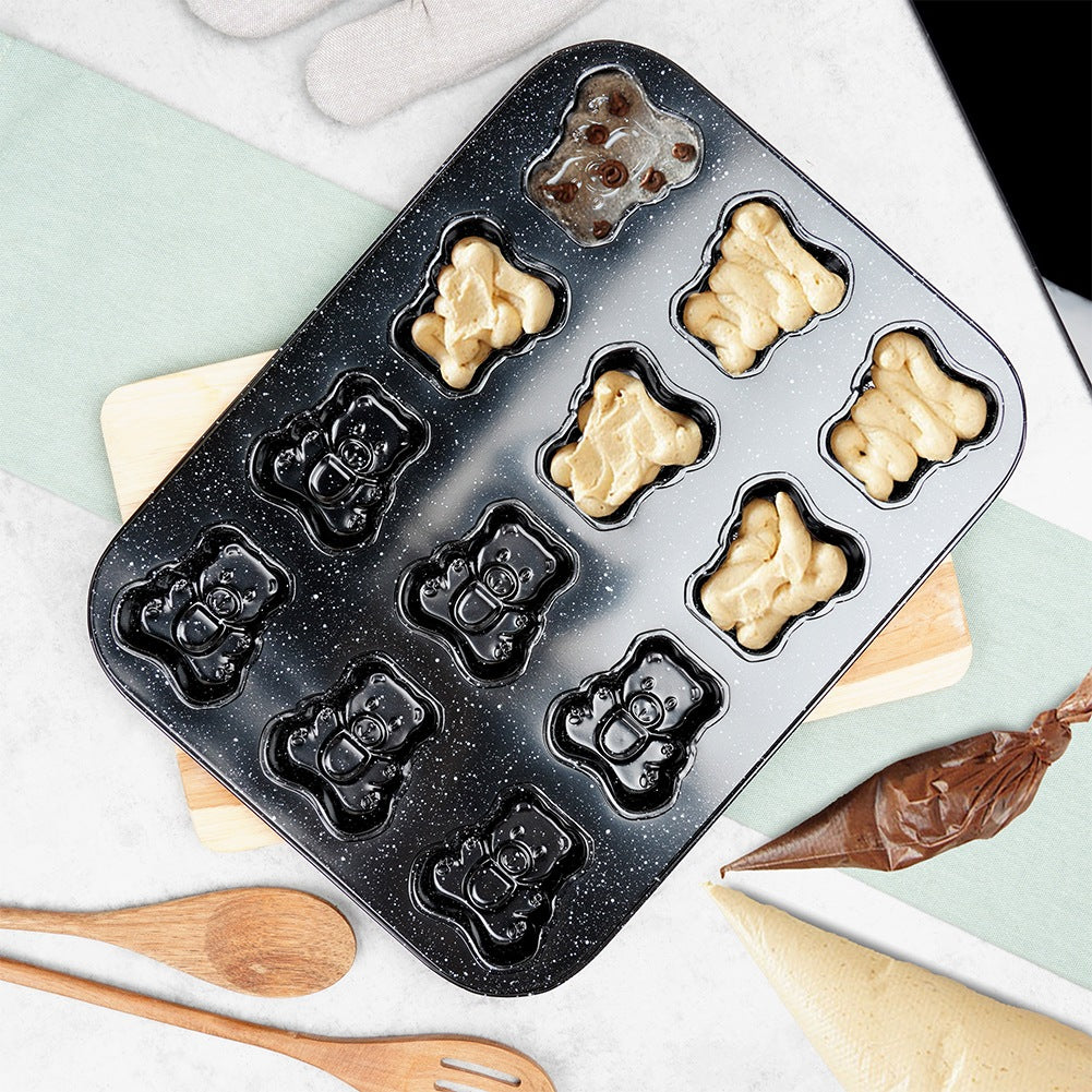Molde para hornear con formas de osito, algunos rellenos de masa, uno con chispas de chocolate.