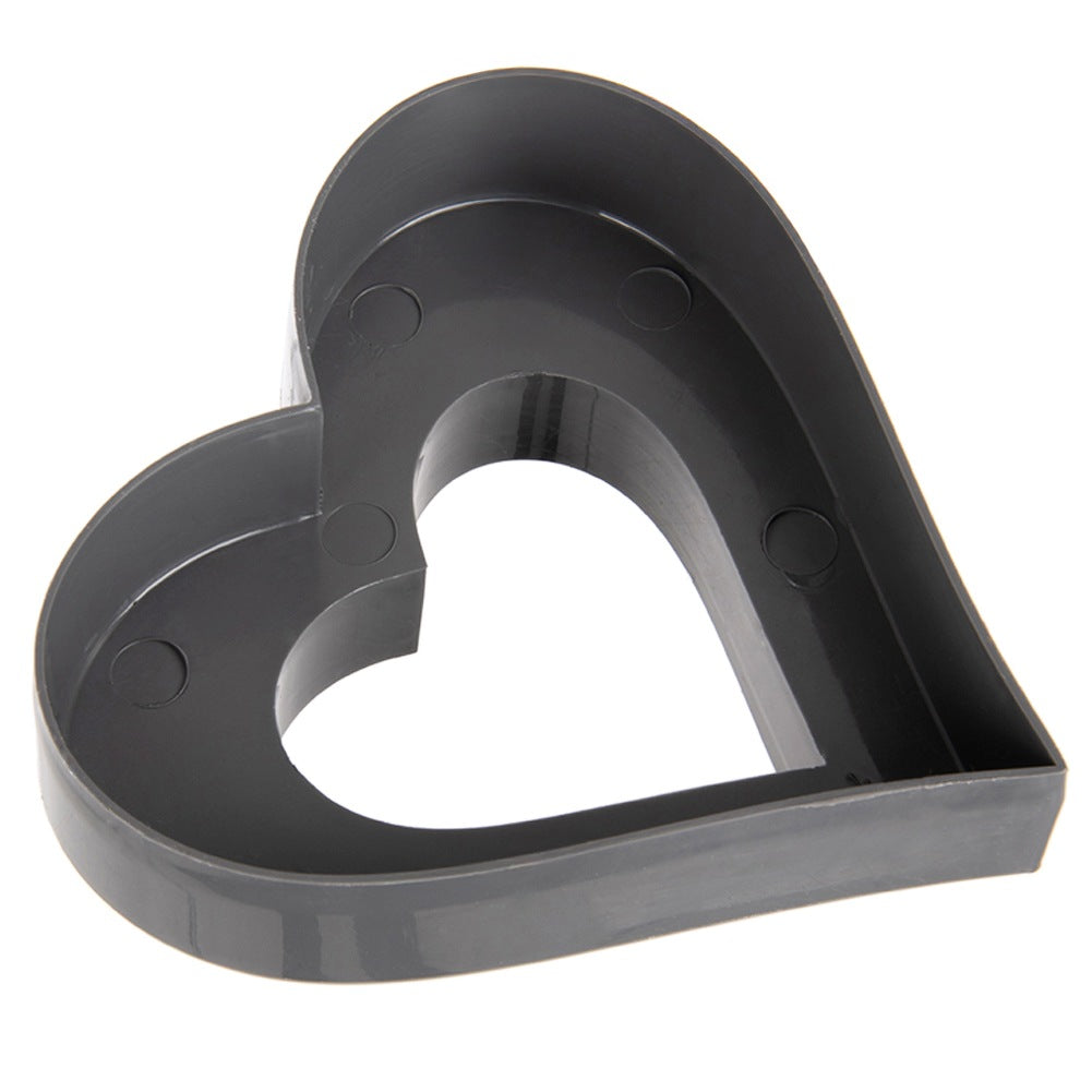 Un cortador de galletas en forma de corazón de plástico gris oscuro.