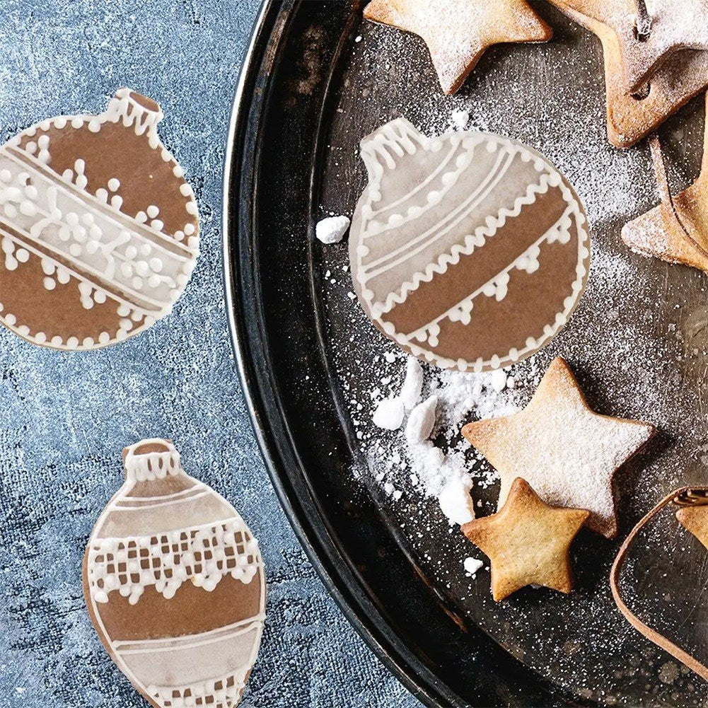Galletas de jengibre con forma de adornos navideños y estrellas en una bandeja.