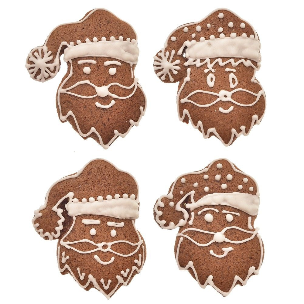 Cuatro galletas de jengibre de Papá Noel decoradas con glaseado blanco sobre fondo blanco.