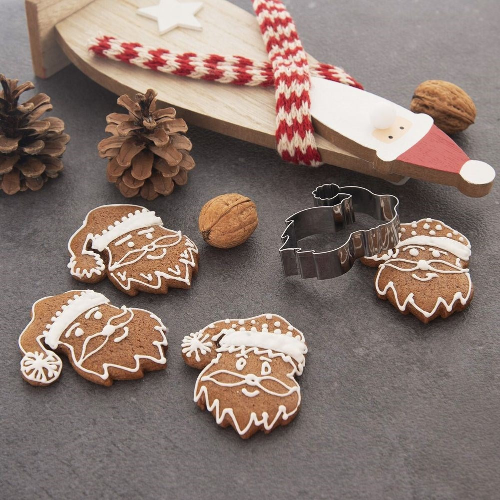 Galletas de jengibre de Papá Noel con glaseado, nueces y piñas sobre una mesa.
