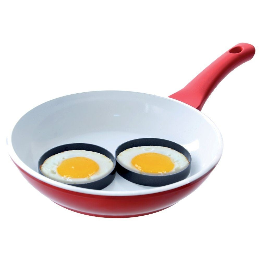 Dos huevos fritos en sartén roja con aros.
