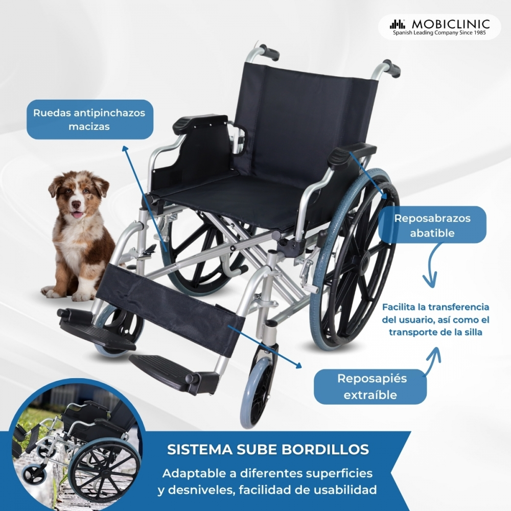Un perro sentado junto a una silla de ruedas con ruedas antipinchazos y reposapiés.