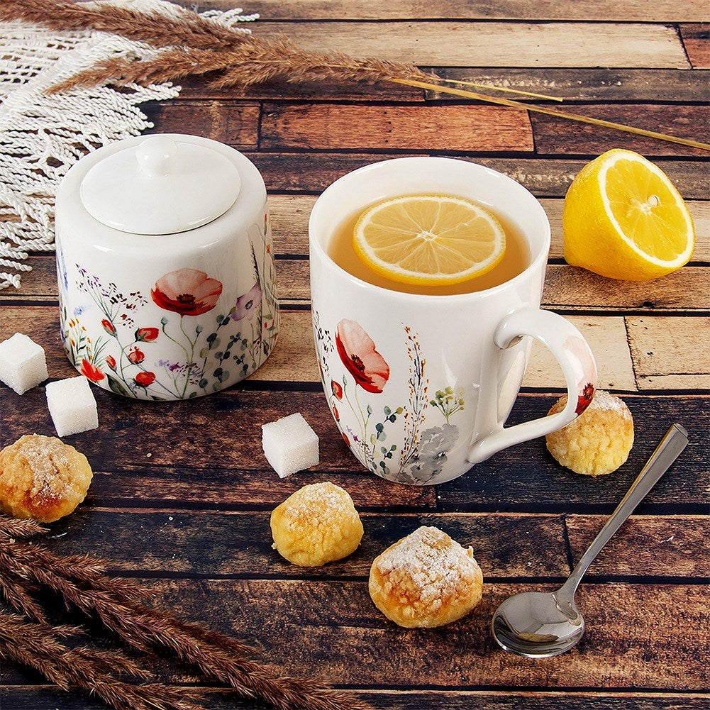 Una taza de té con limón, azucarero, pasteles y cuchara sobre fondo de madera.