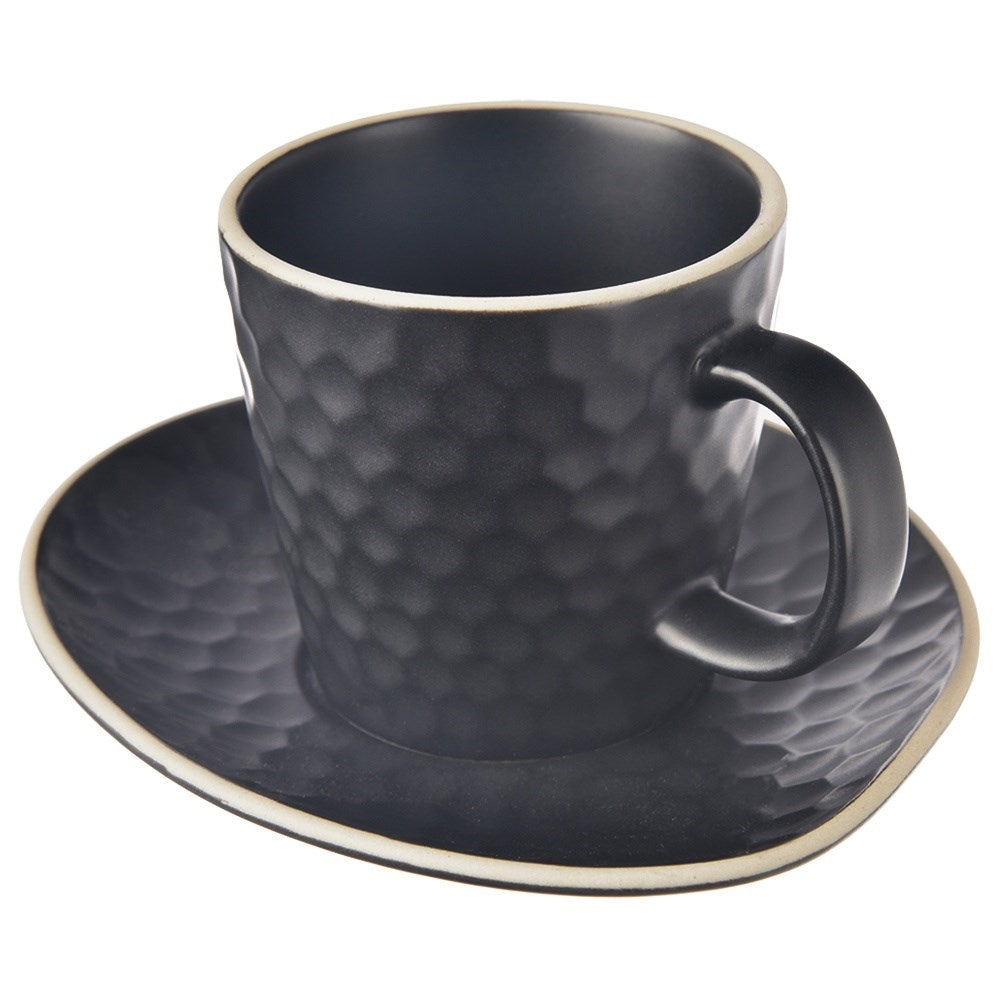 Una taza negra texturizada con patrón de panal en un platillo a juego.