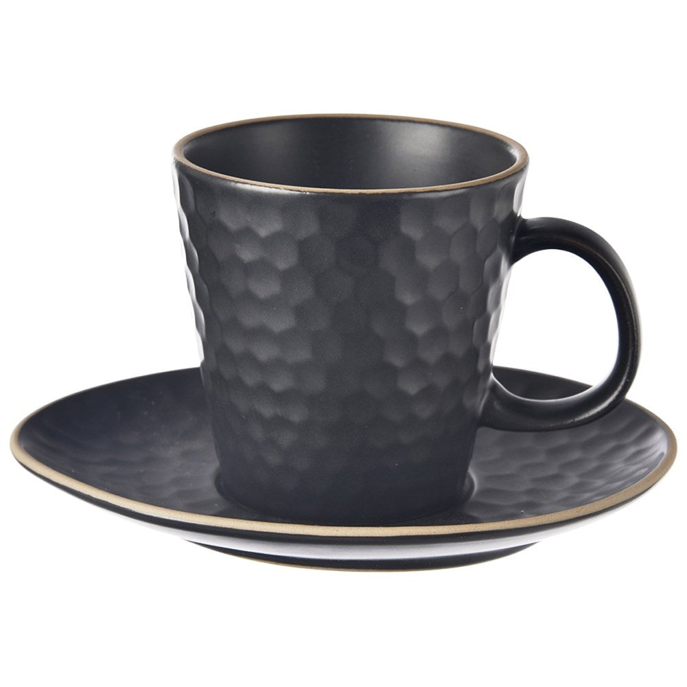 Una taza negra con textura de panal sobre un platillo a juego.