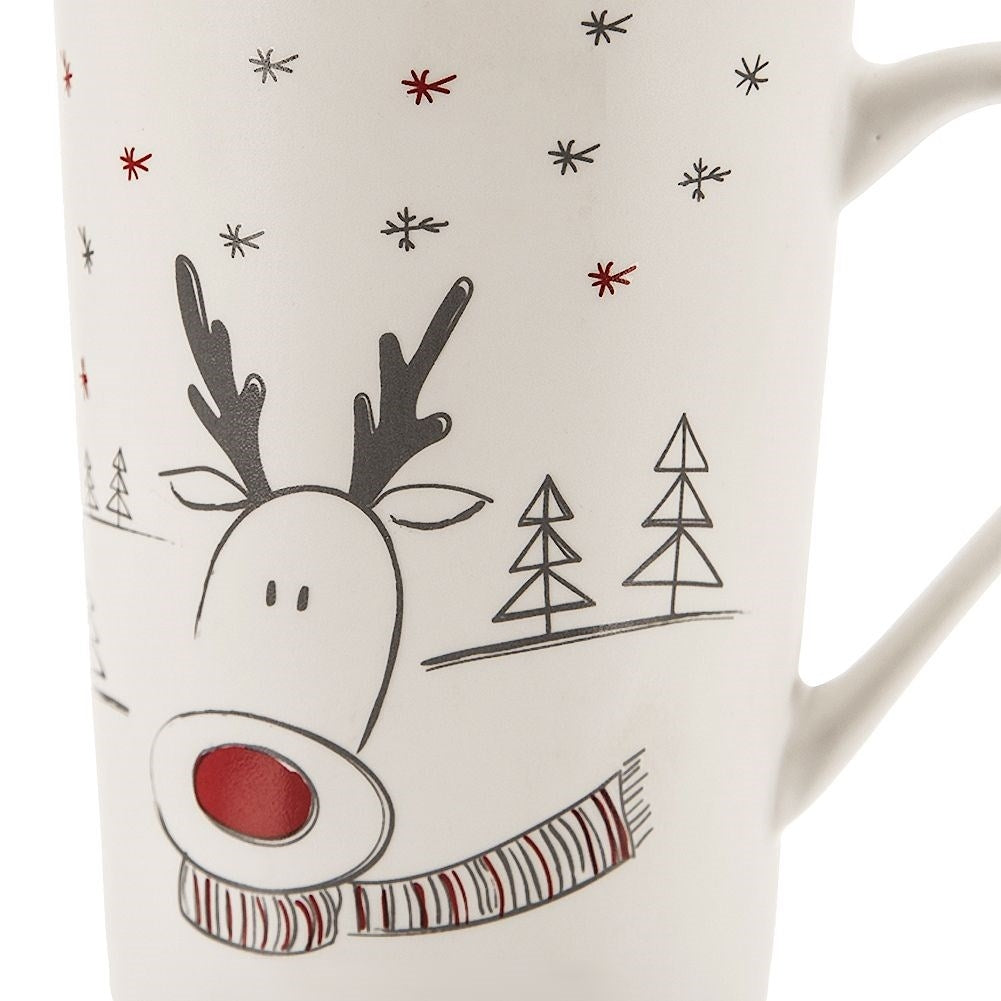 Primer plano de una taza con diseño navideño de reno y copos de nieve.