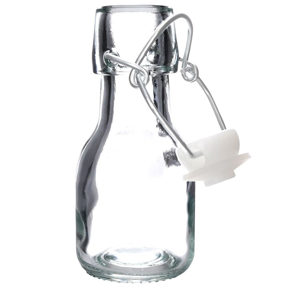 Una pequeña botella de vidrio vacía con cierre de alambre plateado y tapón blanco.