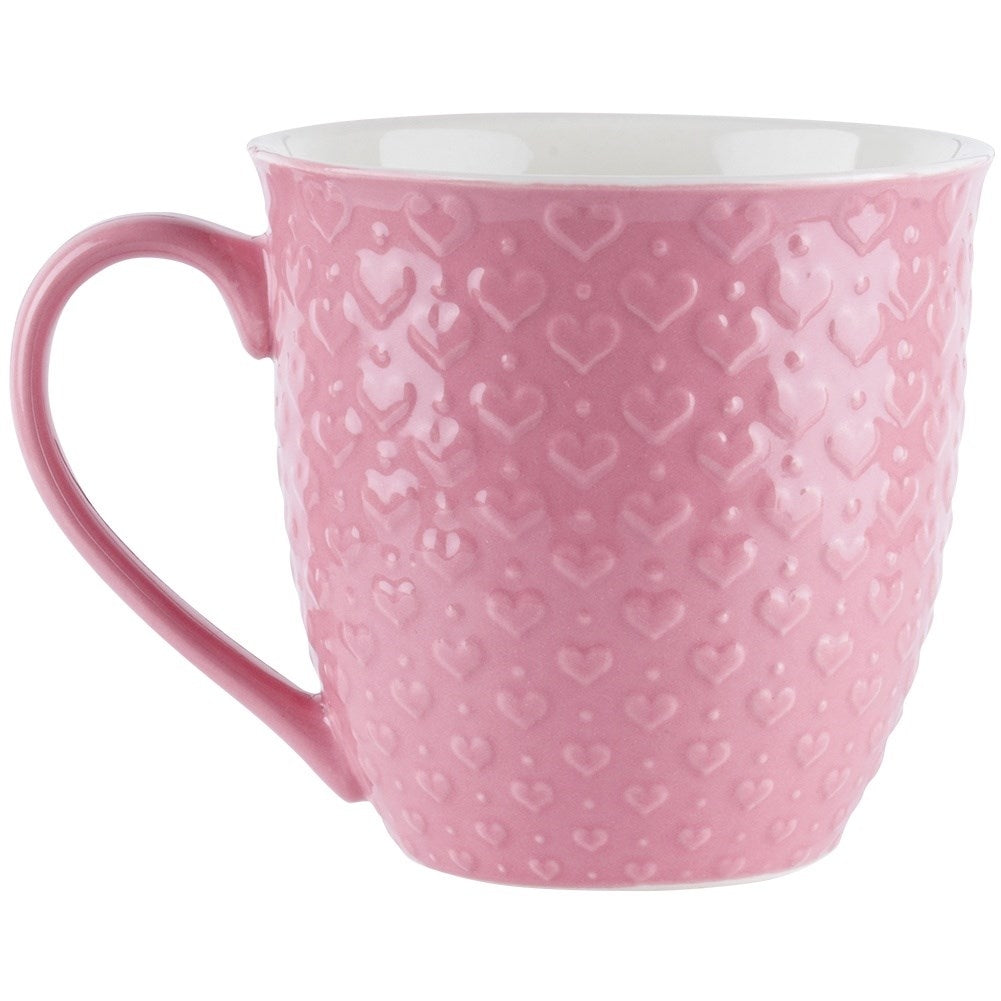 Una taza rosa con patrón de corazones, borde y asa blancos.