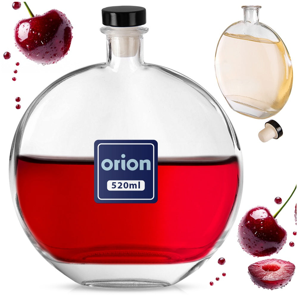 Botella redonda de vidrio con líquido rojo, cerezas y una botella más pequeña.