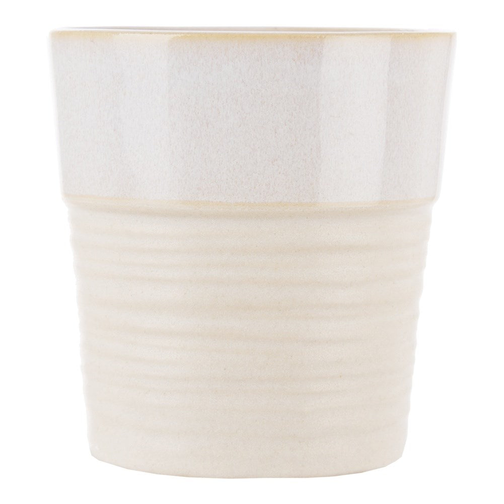 Una taza de cerámica color crema con una sección inferior acanalada y superior lisa.