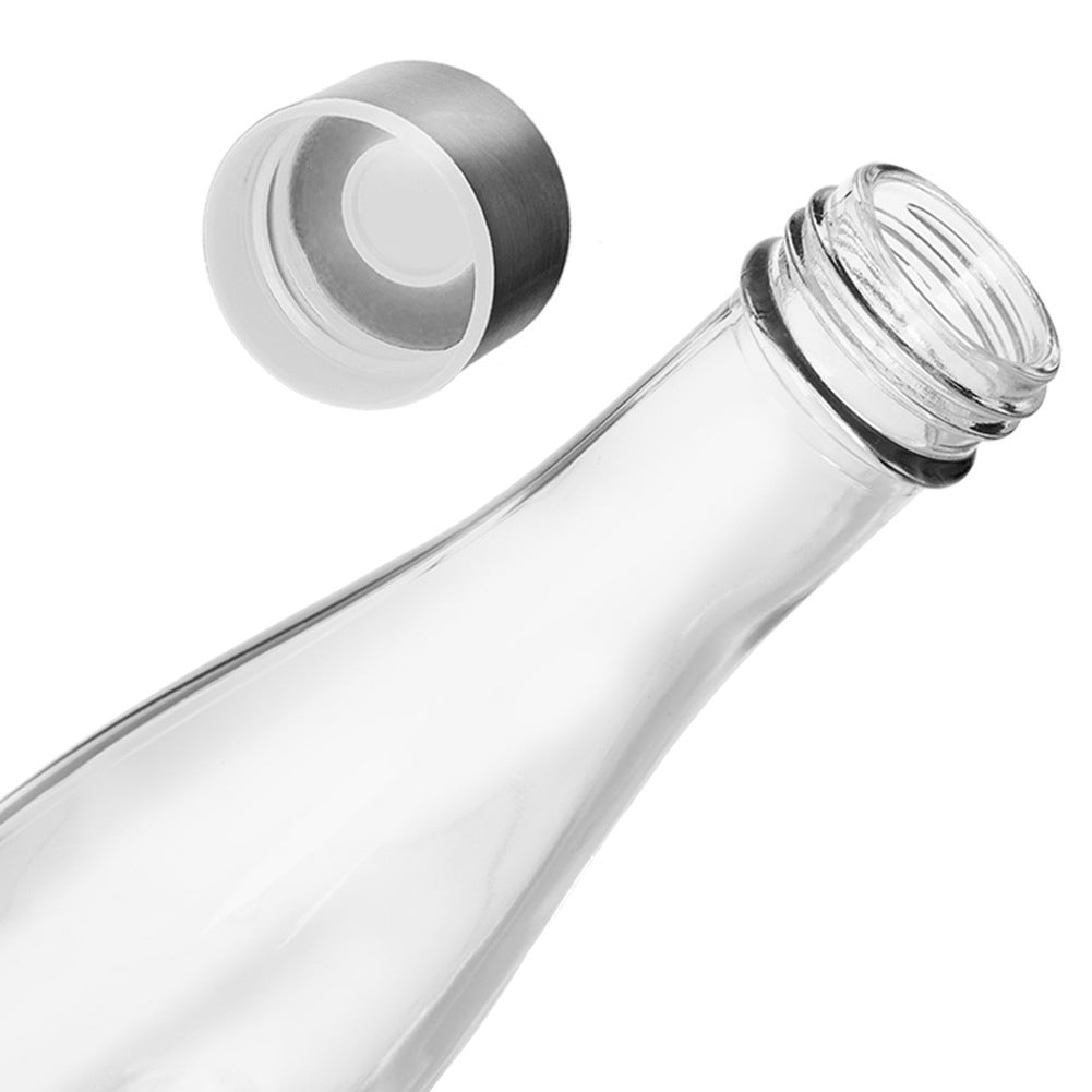 Una botella de vidrio transparente con cuello abierto y tapa plateada separada.