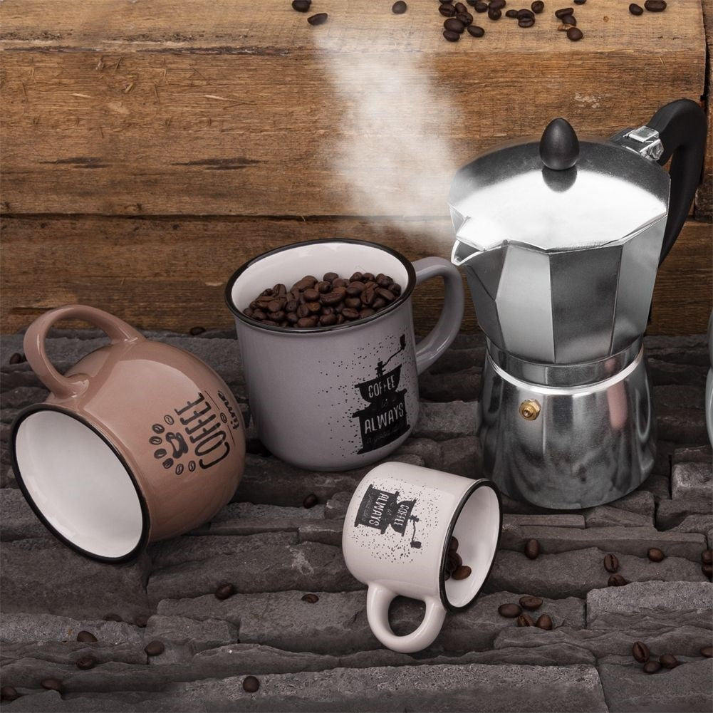 Cafetera con tres tazas sobre piedra y madera, con granos de café.