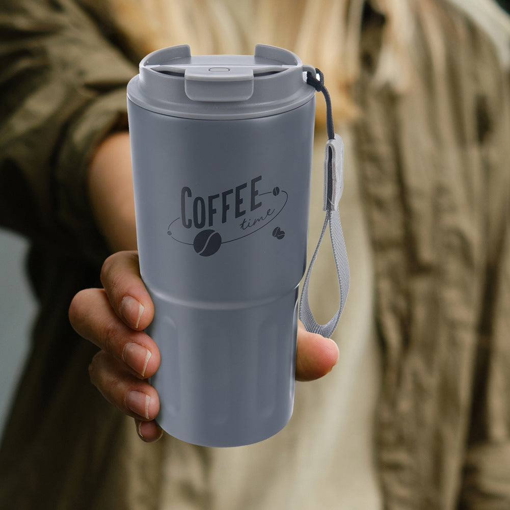 Taza de café gris con asa y estampado "Coffee time" en una mano.