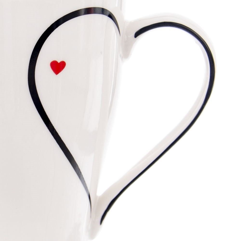 Taza blanca con asa en forma de corazón y un pequeño corazón rojo.
