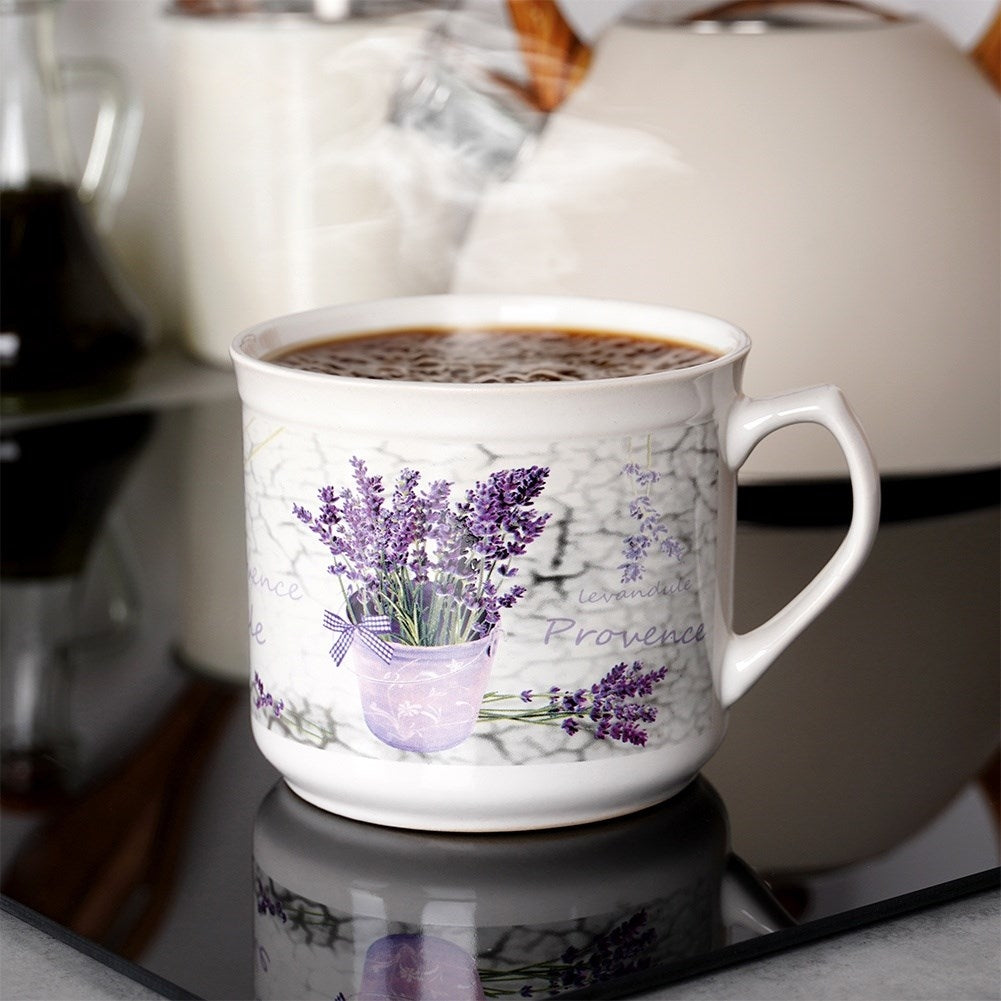 Una taza de café humeante con diseño de lavanda está sobre una estufa brillante.