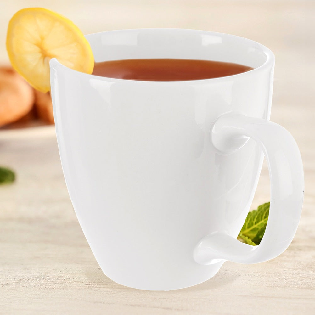 Una taza blanca con té, decorada con una rodaja de limón y menta.