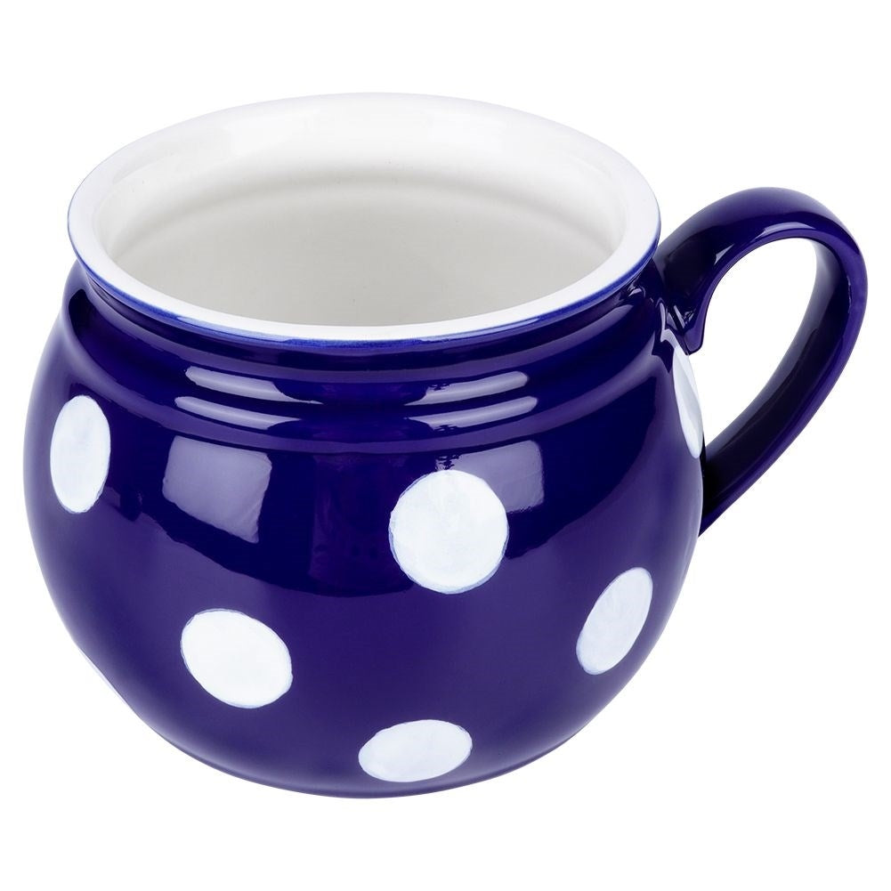 Una taza de cerámica azul oscuro con lunares blancos y un asa.