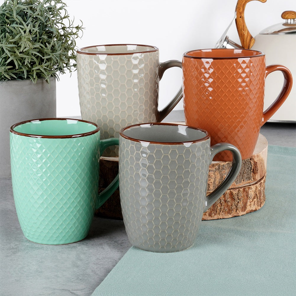 Cuatro tazas texturizadas en verde menta, gris, beige y naranja con patrón de panal.