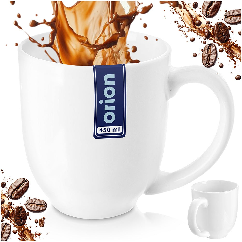 Una taza blanca con salpicadura de café y granos. Una taza más pequeña al lado.