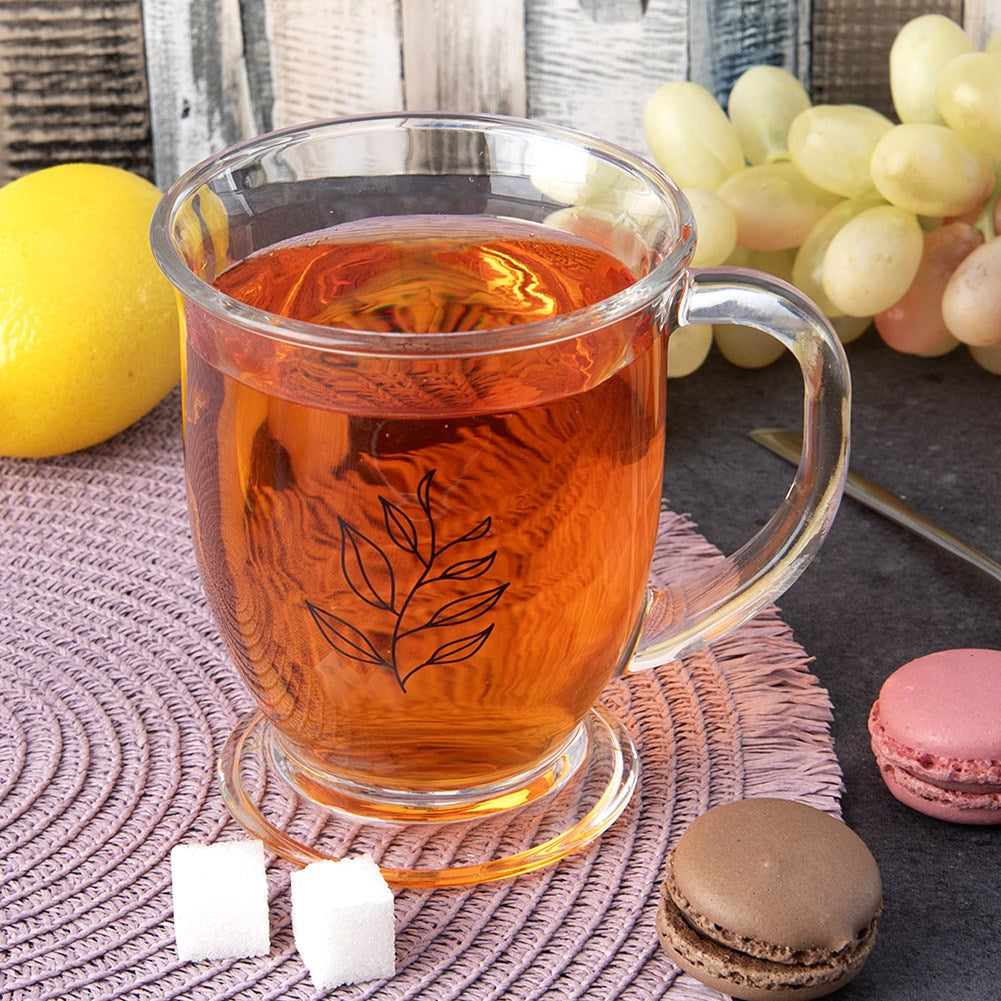 Taza de té de cristal con limón, uvas, terrones de azúcar y macarons.