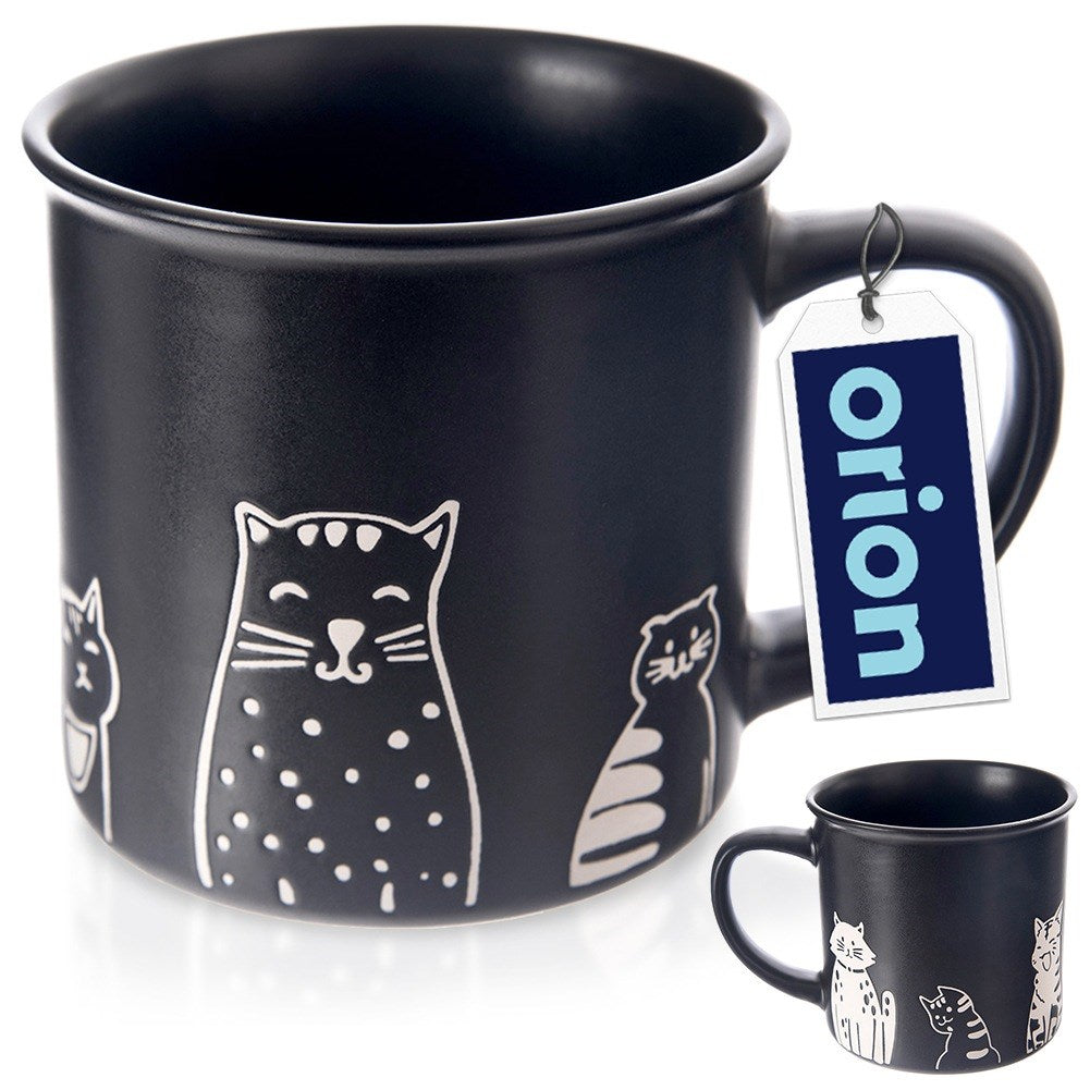 Una taza negra decorada con contornos blancos de gatos y una etiqueta azul.
