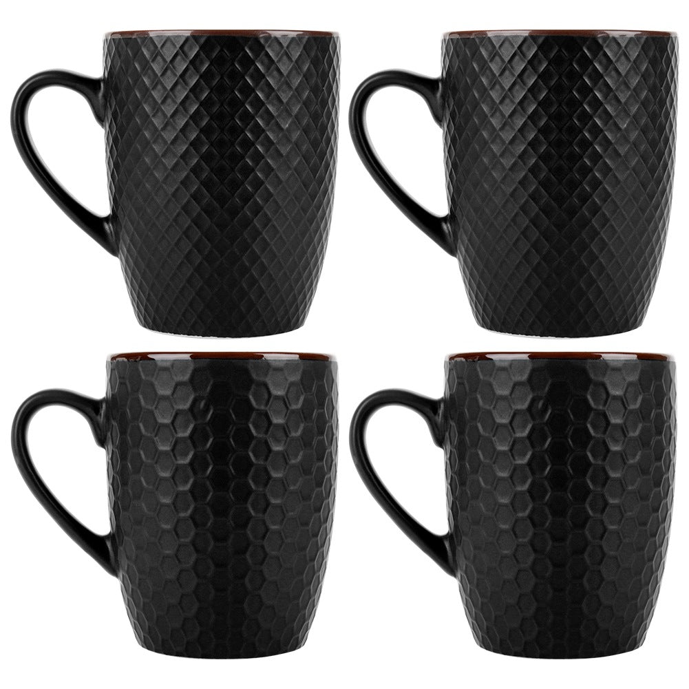 Cuatro tazas negras con asas y superficies texturizadas, sobre fondo blanco.