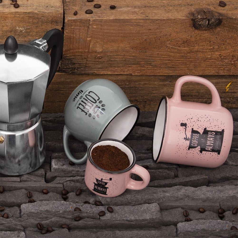 Una cafetera moka, tres tazas de café y granos de café sobre piedra y madera.