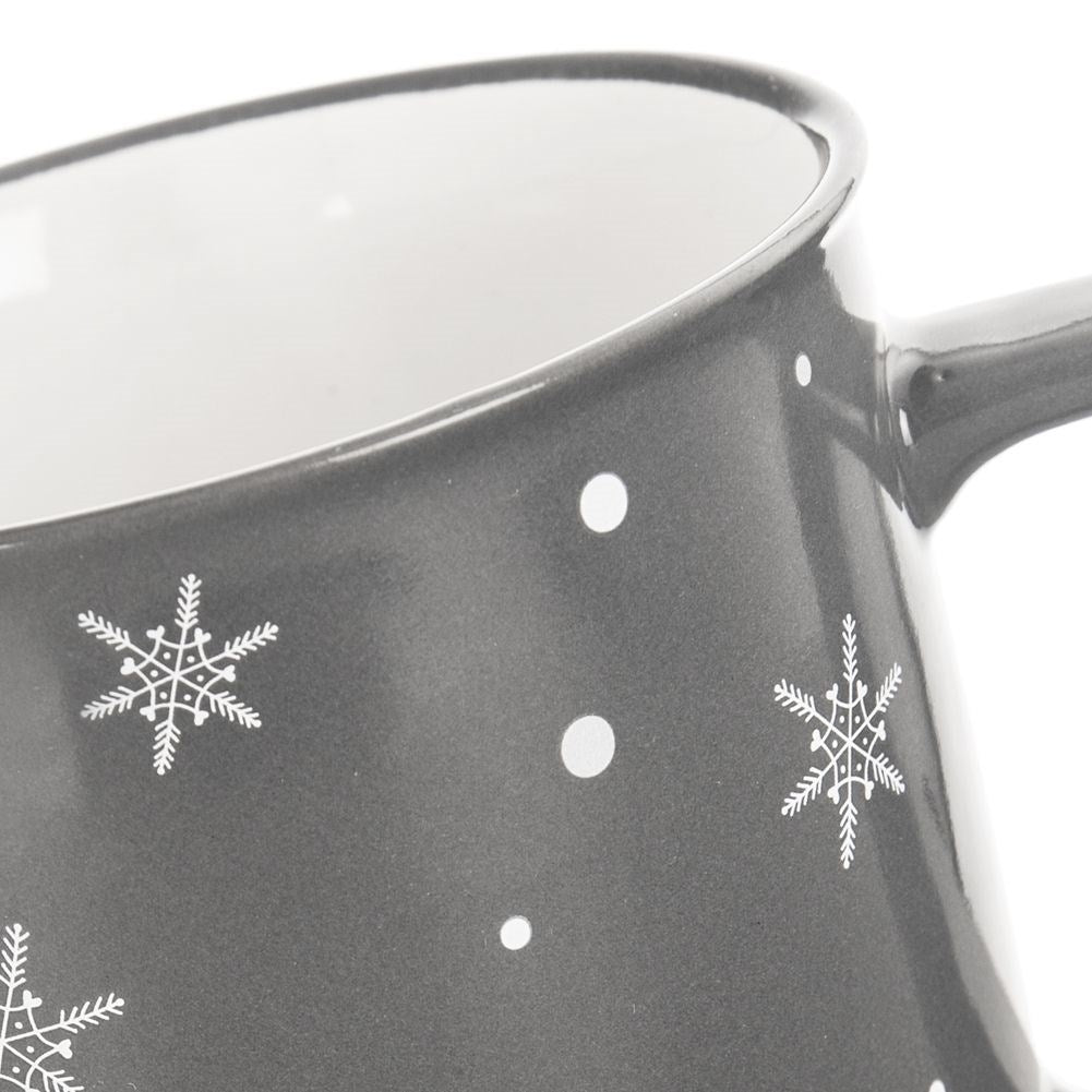 Taza gris decorada con copos de nieve y puntos blancos.