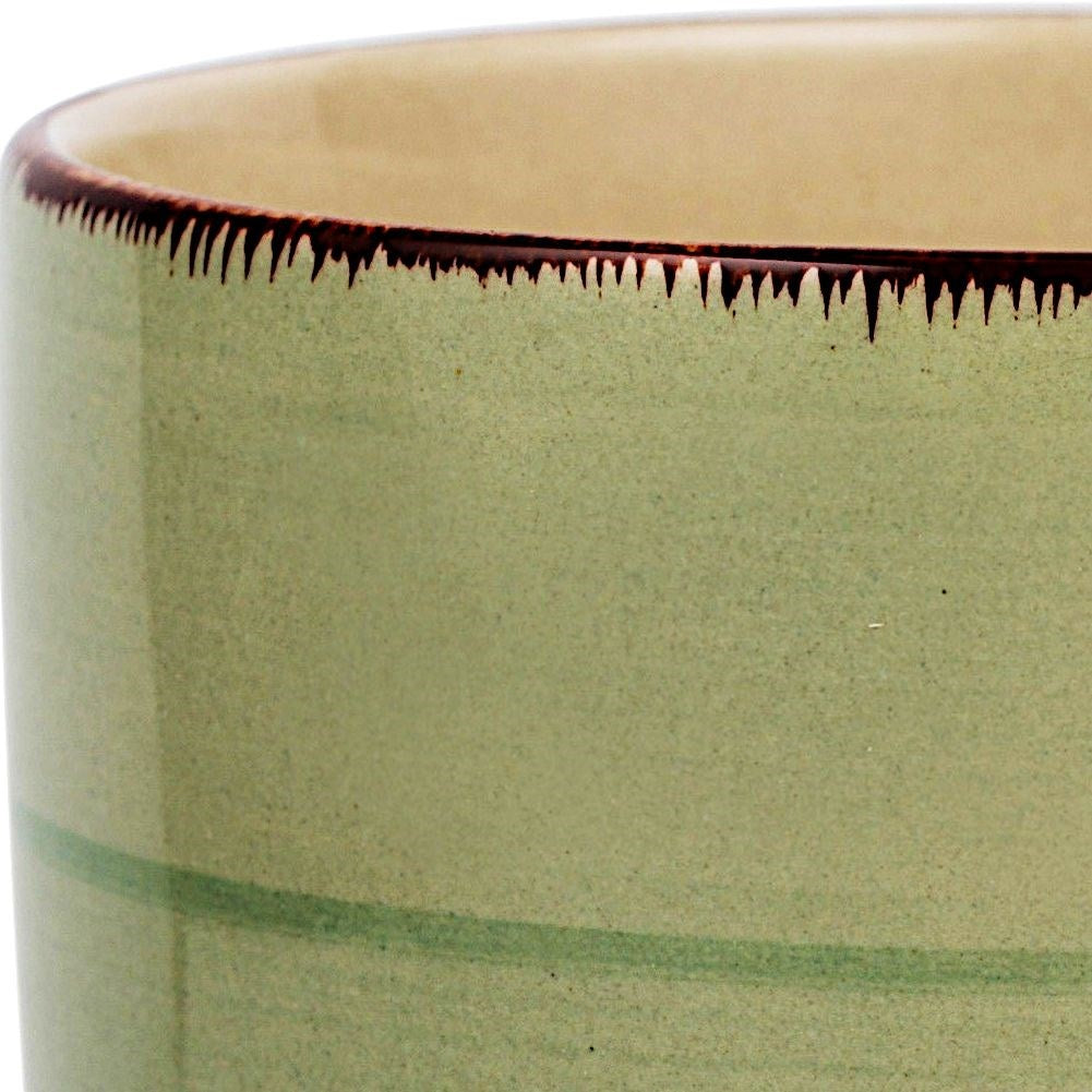 Taza verde con borde oscuro y rayas de acuarela.
