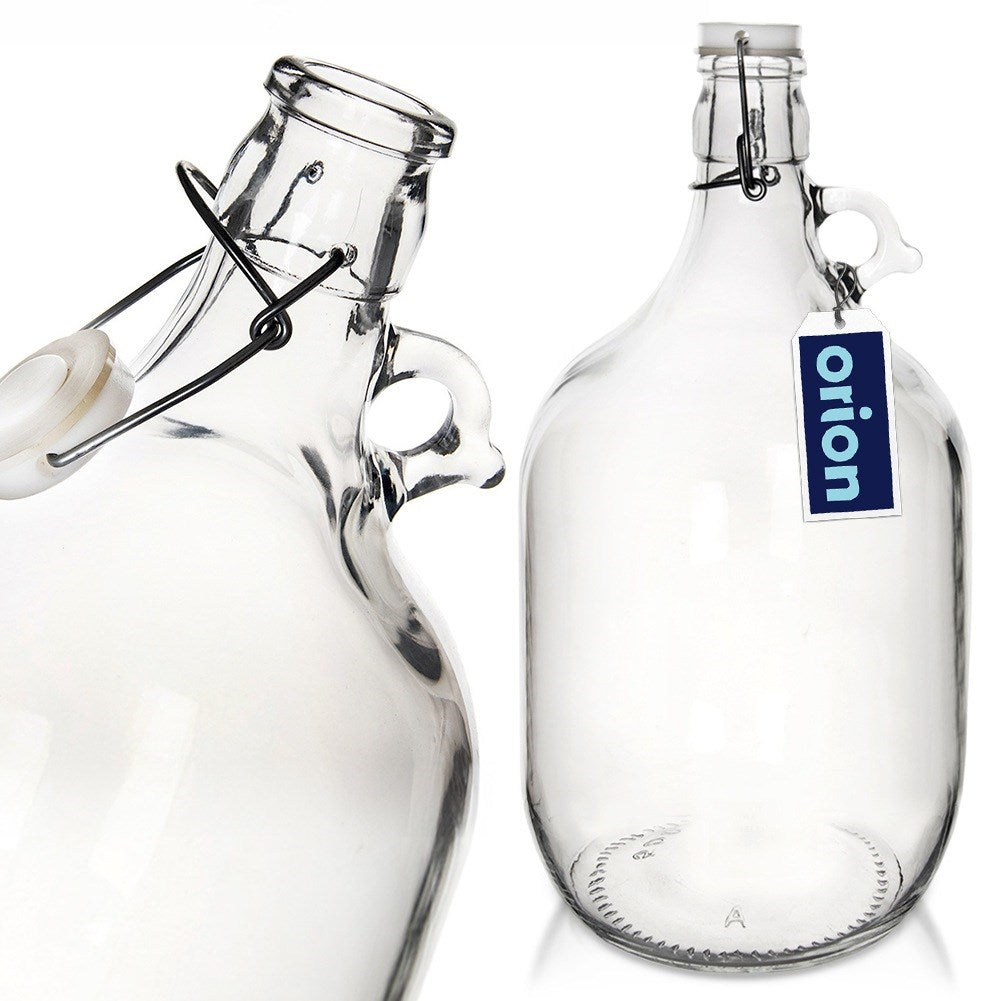Dos jarras de cristal transparente con asas y cierres abatibles, una con etiqueta.