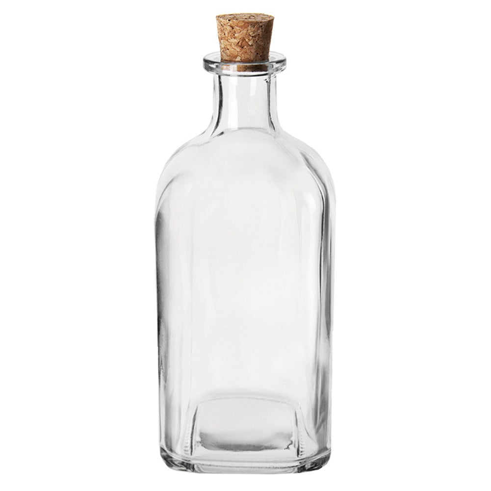 Una botella de vidrio vacía sellada con un corcho, sobre fondo blanco.