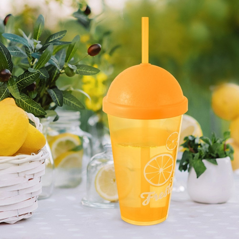 Una bebida amarilla en un vaso transparente con pajita y decoración de naranjas.