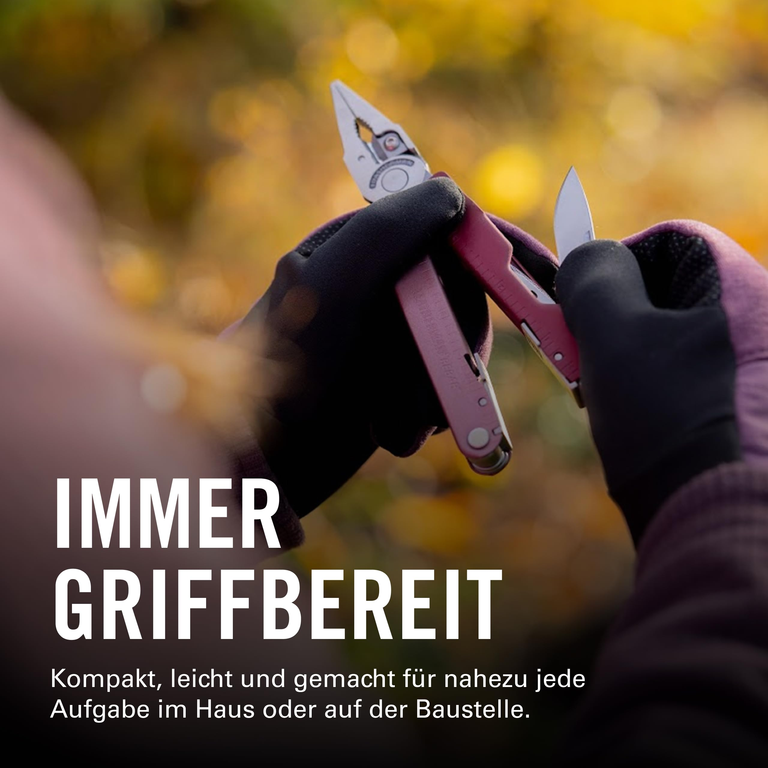 Hände mit Handschuhen halten ein Werkzeug mit Zange und Messer vor unscharfem Herbstlaub.