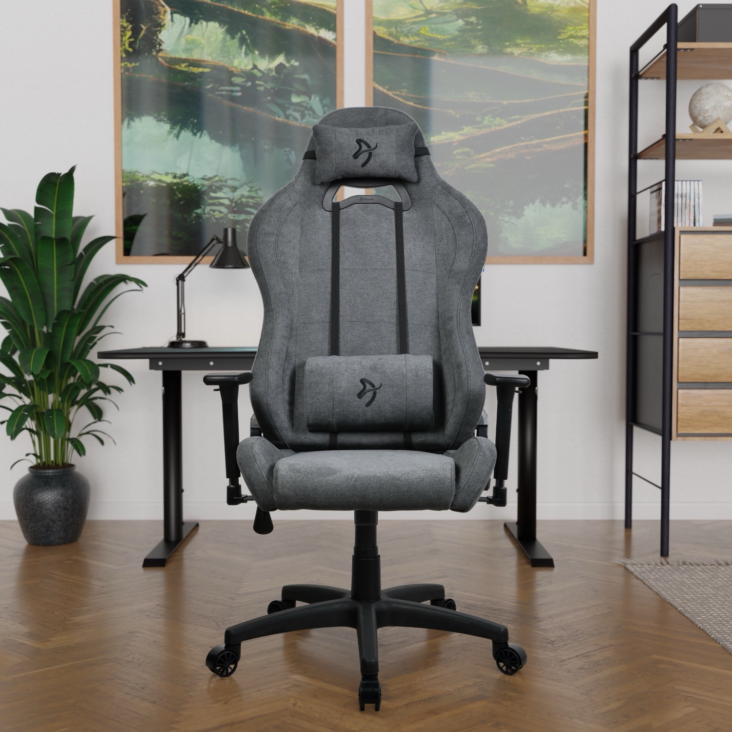 Een grijze gamestoel met hoofd- en lendekussens voor een bureau.