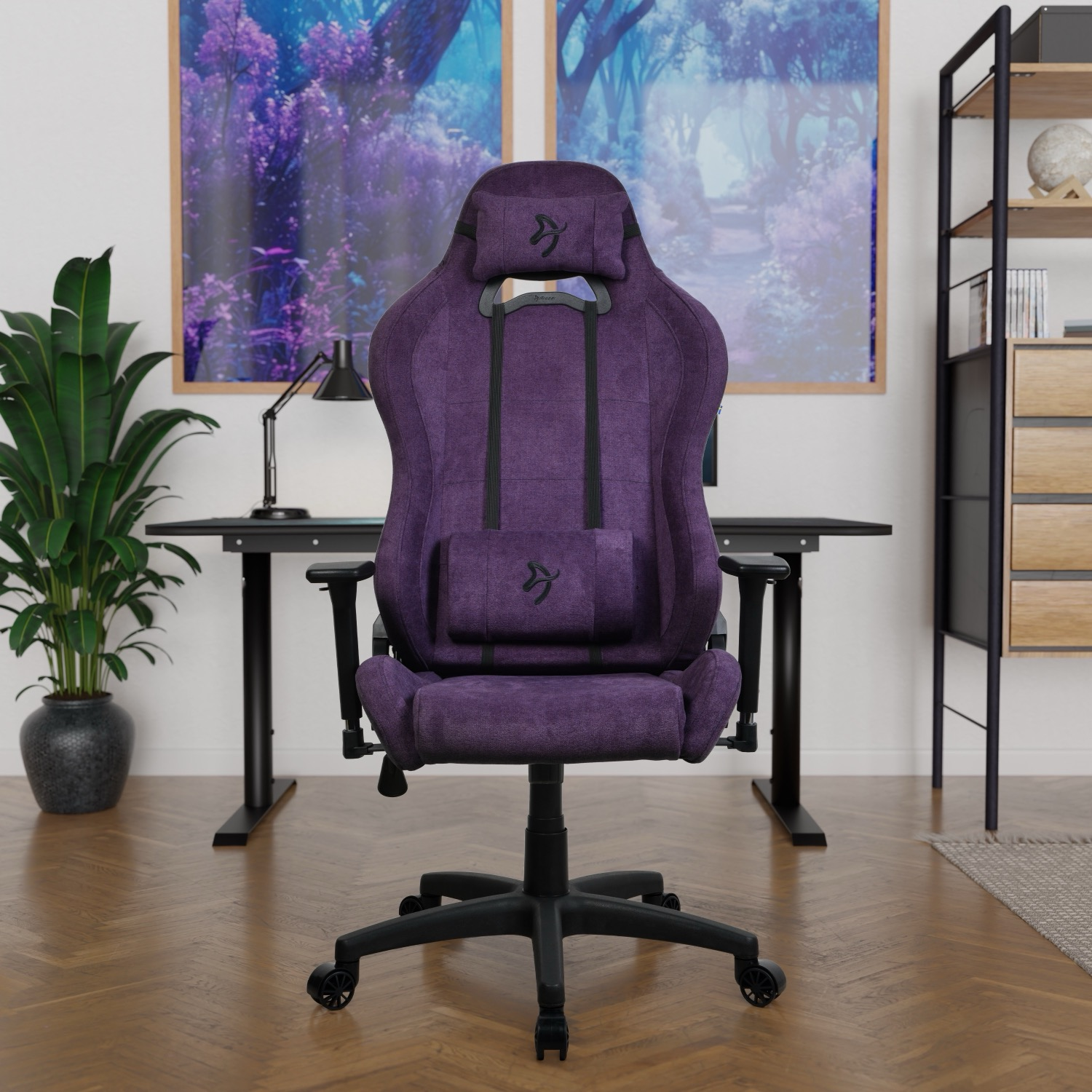 Paarse gamestoel voor een bureau met kunst en planten.