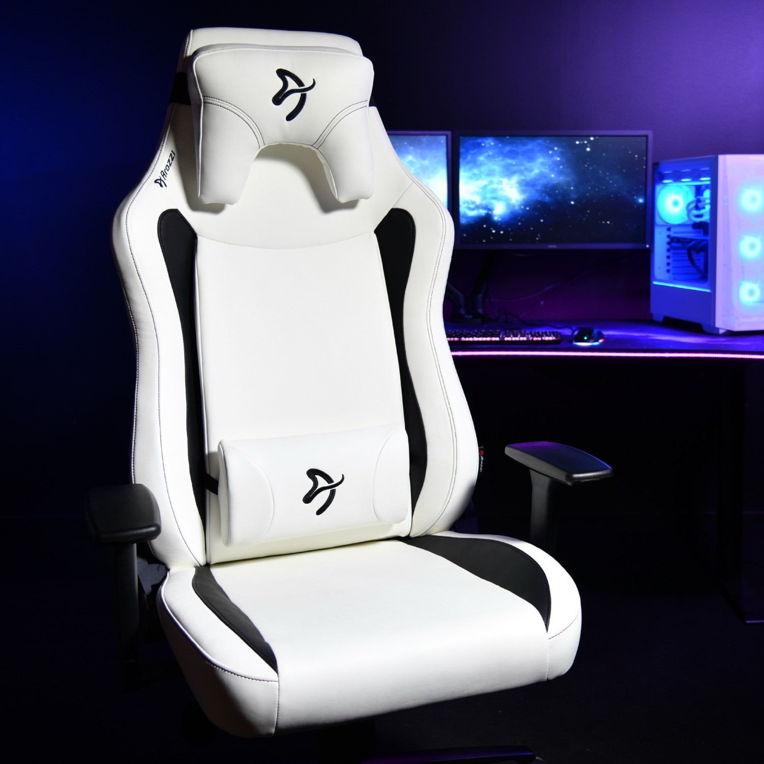 Een witte gamestoel met zwarte accenten staat voor een bureau met computers.