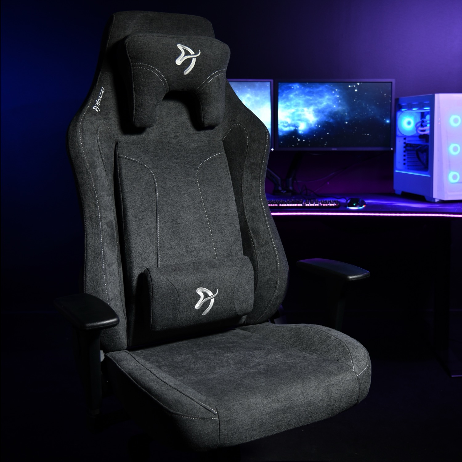 Een donkergrijze gamestoel met hoofdsteun en lendenkussen voor een computer.