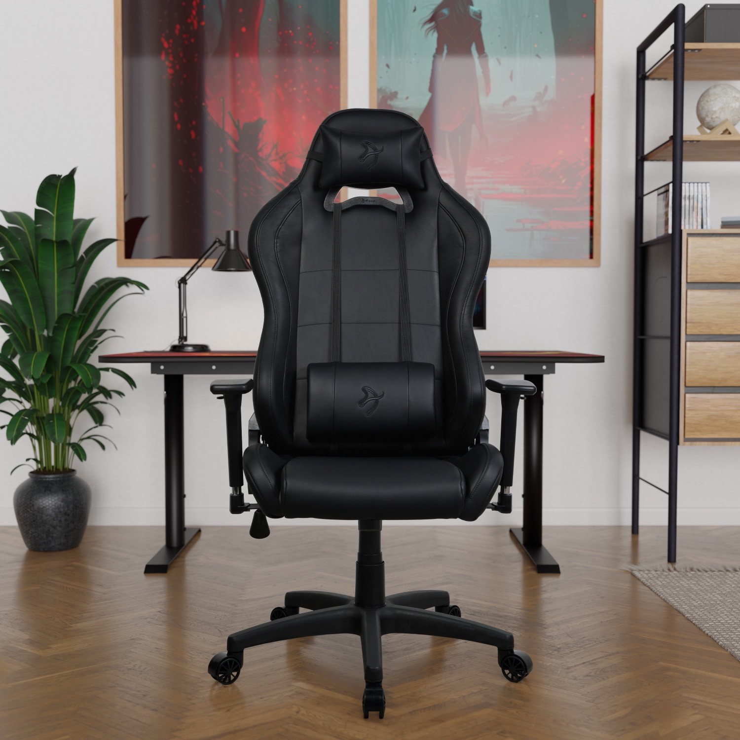 Zwarte gamestoel voor een bureau met kunst aan de muur.
