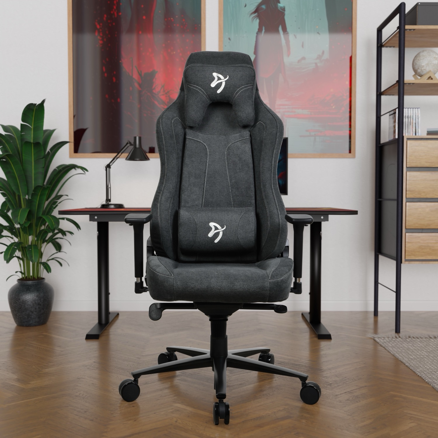 Een donkergrijze gamestoel voor een bureau met twee posters.