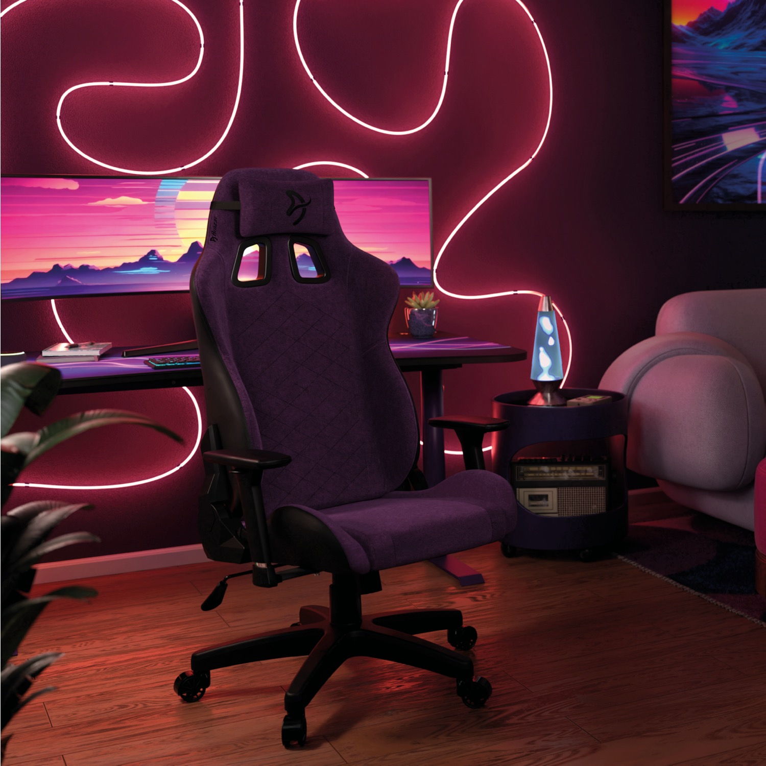 Een paarse gamestoel staat voor een bureau met monitor en neonverlichting.