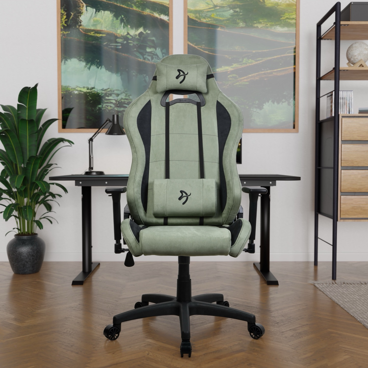 Een groene gamestoel met zwarte accenten staat in een kamer met een bureau en kunst.